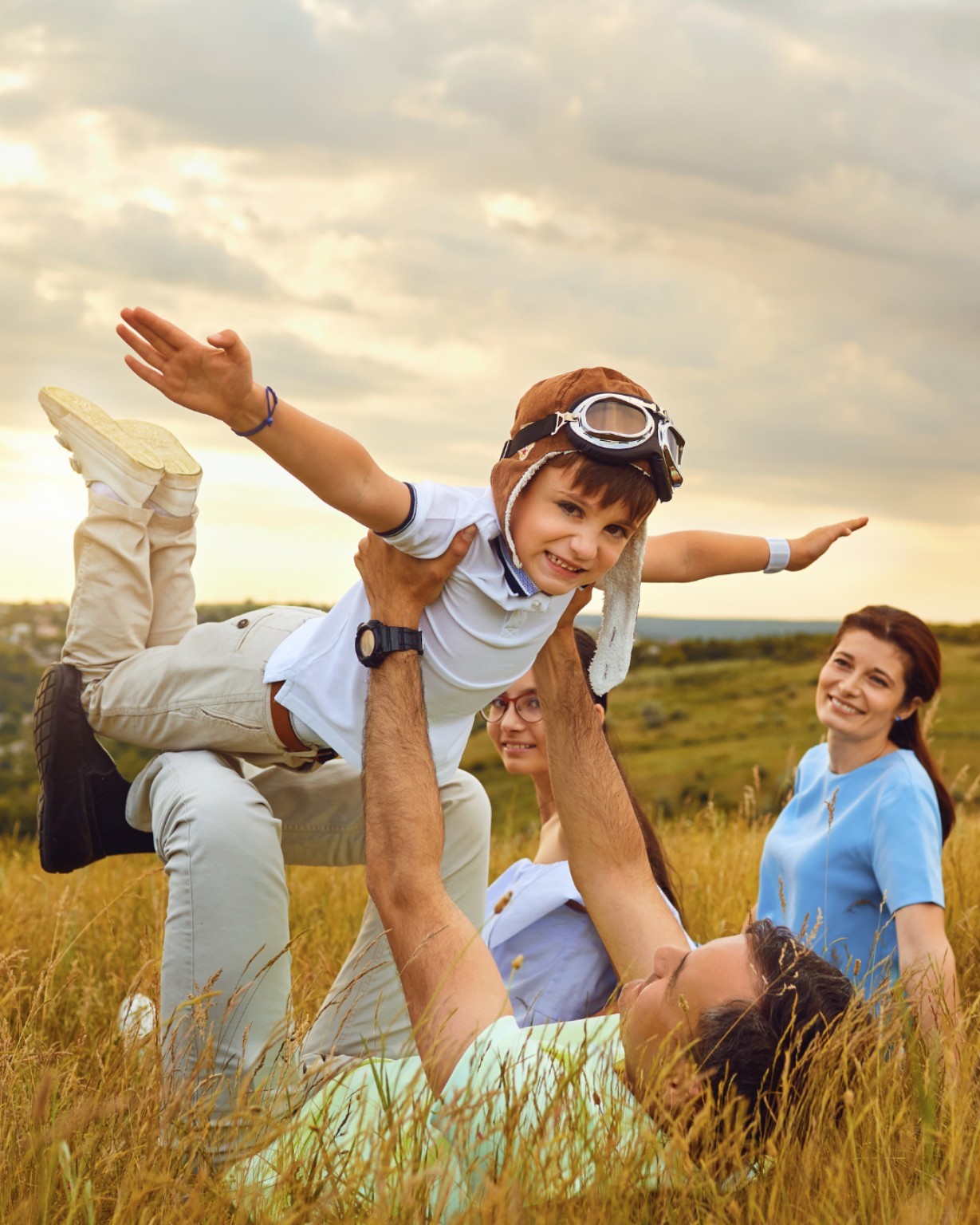 Fotografía original de una familia jugando en el campo al atardecer
